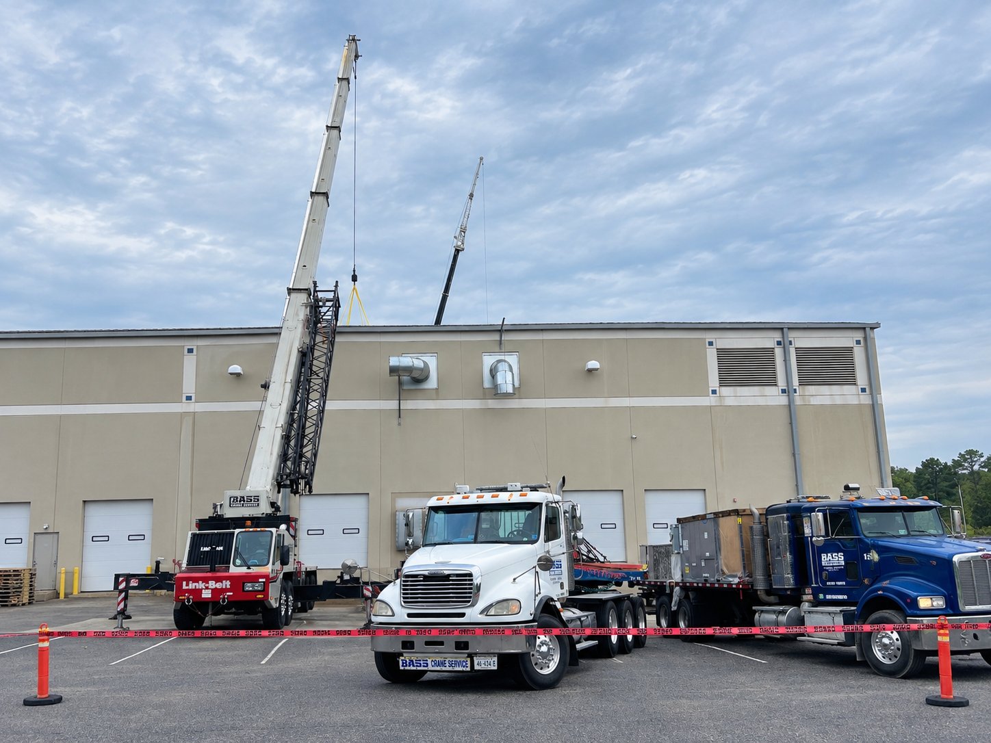 Bass Crane and trucks staged at a commercial building for a rooftop lift