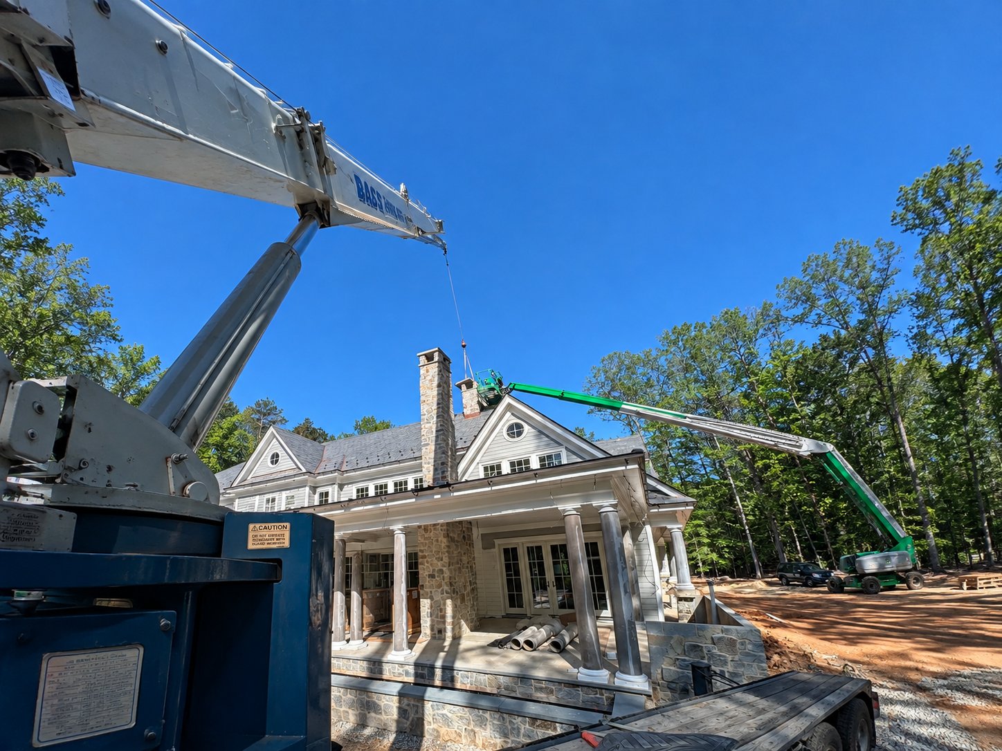 Boom truck lifting materials over a residential home build